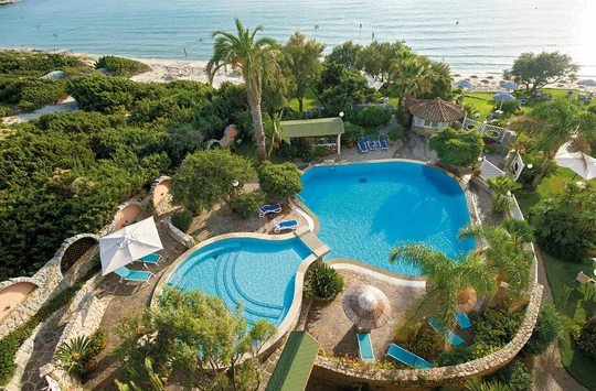 Der Pool vom Hotel Stella Maris auf Sardinien mit dem blauen Meer im Hintergrund.