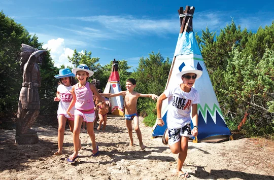 Spielende Kinder zwischen Indianerzelten
