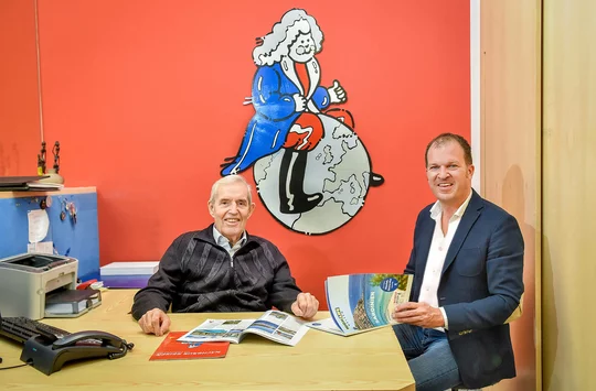 Emil Nachbaur und sein Neffe Michael Nachbaur blättern zusammen durch Kataloge