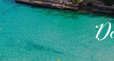 Ein Strand mit klarem, blauem Wasser und grünen Büschen. Rechts ist der Schriftzug 