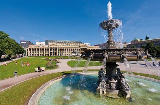 Der Schlossplatz in Stuttgart im Sommer mit Springbrunnen im Vordergrund