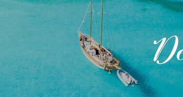 Eine Luftaufnahme eines Strandes. Rechts ist der Schriftzug 