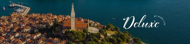 Eine Luftaufnahme der Insel Rovinj in Kroatien. Auf der Insel sind viele kleine Häuser und in der Mitte eine Kirche. Rechts ist der Schriftzug 