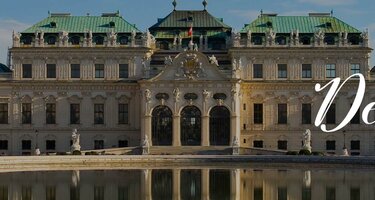 Das reich verzierte Schloss Belvedere in Wien. Vor dem Schloss ist ein Teich, in dem sich das Schloss spiegelt. Rechts ist der Schriftzug 